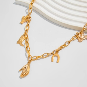 Close-up of golden chain necklace featuring western cowboy boot and cactus charms