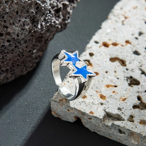 Detailed view of silver-toned hammer-textured open ring with blue enamel double stars