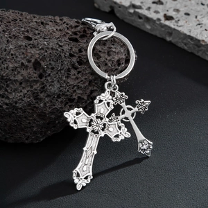 Detailed macro shot of vintage silver cross pendants on a dark volcanic rock background
