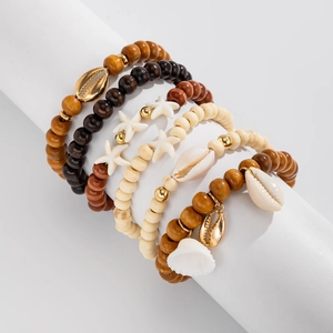 Dettaglio ravvicinato di set di braccialetti bohémien con conchiglie e ciondoli a stella