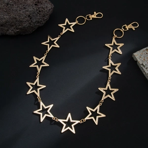 Macro shot of gold hollow pentagram metal chain with lobster clasps on black background