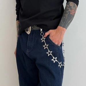 Detail of silver star chain link accessory on dark denim pants with lobster clasp