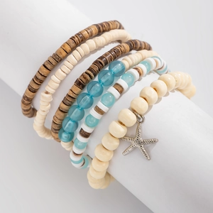Detail of bohemian coconut shell beaded bracelet set with silver starfish charm
