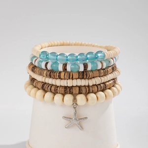 Detail of bohemian coconut bead bracelet set featuring a silver starfish charm
