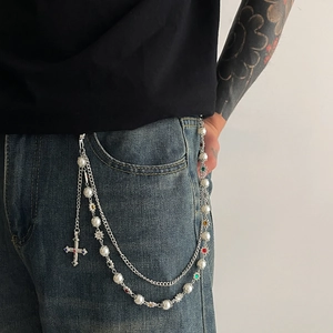 Detail of multi-layer silver pants chain with pearls, colorful flowers and crystal cross