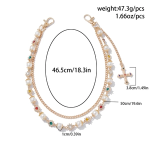 Detailed view of layered gold chain with faux pearls, rhinestones and a cross charm