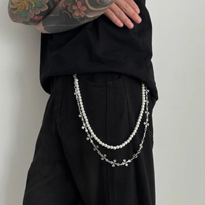 Detail view of double-layered hip-hop waist chain with white pearls and silver crosses