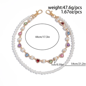Detail showing colorful heart gems with rhinestones and faux pearl chain necklace layers