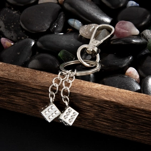 Porte-clés hip hop en métal argenté avec pendentifs double dés sur fond de pierres