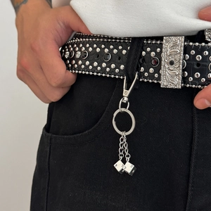 Détail de ceinture en cuir à rivets avec boucle vintage et porte-clés à dés argentés