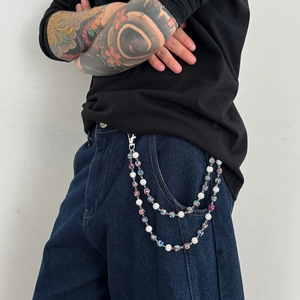 Detailed view of layered hip hop pant chain with colorful rhinestone balls on denim jeans