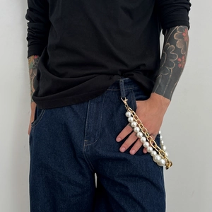Détail de la chaîne de taille hip-hop avec perles blanches et maillons en métal doré