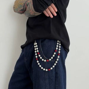 Détail de chaîne de pantalon hip-hop avec perles strass rouge et blanc sur un jean bleu
