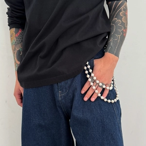 Detail of silver beaded hip hop pants chain with sparkling rhinestones on denim jeans