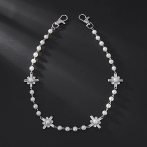 Detail of faux pearl waist chain with silver cross pendants and lobster clasps
