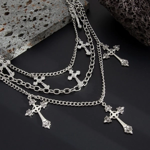 Close-up of multilayer silver punk waist chains with engraved cross pendants and star charms