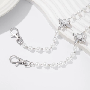 Close-up of pearl and rhinestone cross trouser chain with silver metal lobster clasp