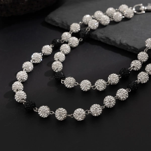 Détail d'une chaîne de taille hip hop avec des sphères alternées en strass argent et noir