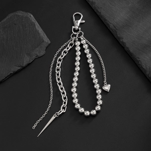 Close-up of punk style silver chain keychain with heart and spike metal charms