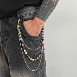 Detail of multi-layered punk pants chain with colorful rhinestone balls and silver links
