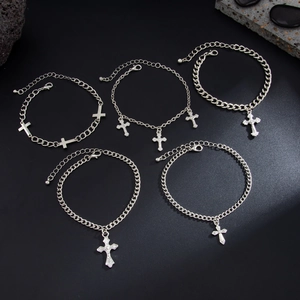 Dettaglio macro di bracciali con ciondolo a croce in metallo argento con chiusura a moschettone