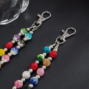 Detailed macro of colorful rhinestone ball pants chain with silver metal lobster clasps