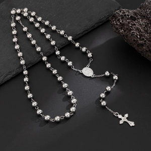 Collier chapelet poli en acier inoxydable avec pendentif croix sur fond de pierre sombre