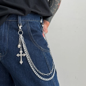 Multi-layer silver metal pants chain with cross and skull charms on dark denim jeans