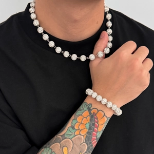 Dettaglio della collana e del bracciale hip-hop con sfere di cristallo su maglia nera