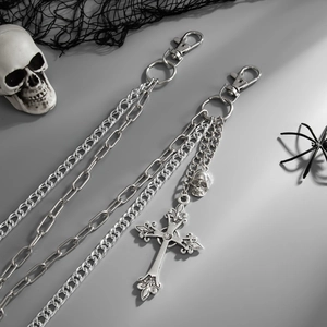 Detail of gothic silver cross and skull pendants on punk multilayer metal wallet chains