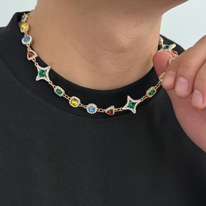 Detailaufnahme einer Vintage-Halskette mit bunten Edelsteinen und goldenen Stern-Motiven