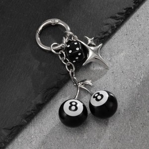 Détail d'un porte-clés hip-hop avec boule de billard n°8 noire et pendentif dé assorti