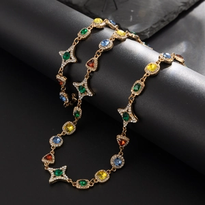 Detail einer luxuriösen Goldkette mit bunten Edelsteinen und funkelnden Pavé-Kristallen