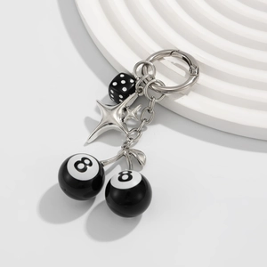 Détail d'un porte-clés hip-hop avec des boules de billard noires et un élément de dé