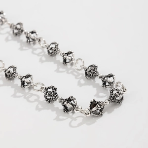 Close-up of vintage punk metal trousers chain with intricate carved vajra style links