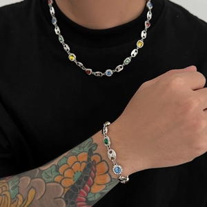 Detailed view of silver coffee bean chain necklace with multi-colored cubic zirconia