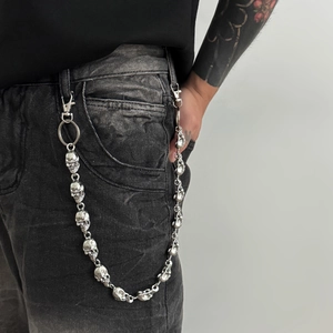 Détail de la chaîne de pantalon tête de mort argentée avec fermoir sur jean noir