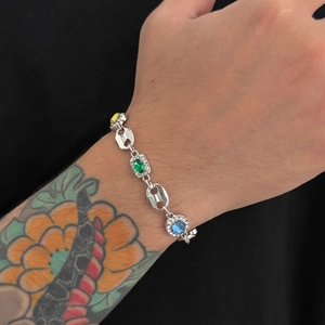 Detailed view of silver coffee bean link bracelet with colorful gems on wrist