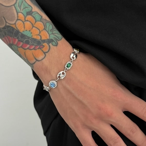 Detail of silver link bracelet with colorful oval gemstones and sparkling crystal pavé