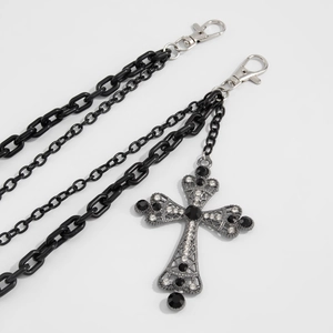 Détail d'une chaîne de pantalon punk noire multicouche avec pendentif croix argentée strassée