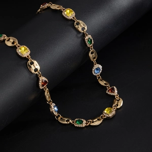 Detailed close-up of golden link chain necklace featuring colorful gemstones and crystals
