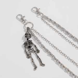 Detail of punk trousers chain featuring a silver skeleton pendant and double metal layers