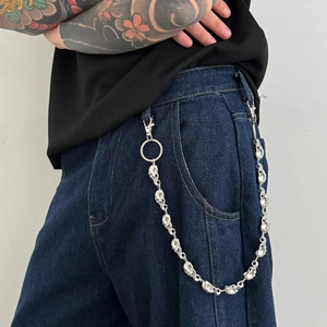 Chaîne de pantalon punk en métal argenté avec petits crânes sur un jean bleu