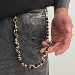 Close-up of hip-hop waist chain with chunky gold links and polished black beads