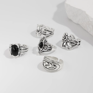 Dettaglio di anelli vintage in argento con motivi traforati e pietre nere