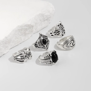 Dettaglio di cinque anelli vintage in lega d'argento con pietre nere e incisioni boho