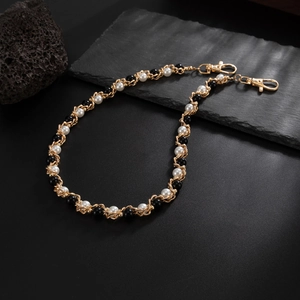 Detailed close-up of hip-hop waist chain featuring black beads and white pearls on hooks