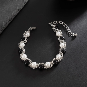 Detail van een zilveren ketting met witte parels en zwarte kralen voor heren