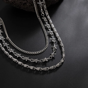 Detailed view of layered silver punk chains featuring star pendants and textured metal links
