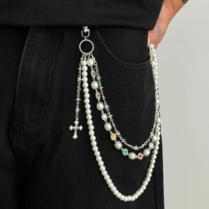 Detail of multi-layered hip hop trouser chain with pearls and silver cross pendant
